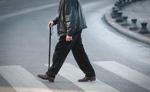 Un homme âgé traverse une route (illustration)