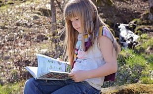 Une petite fille en train de lire.