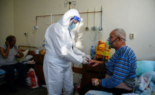 Un médecin examine un patient à l'unité Covid-19 d'un hôpital de Kjustendil le 19 octobre 2021, l'une des municipalités de la « zone rouge sombre Covid » de Bulgarie, où plus de 500 personnes sur 100 000 sont infectées par le coronavirus (Covid19).