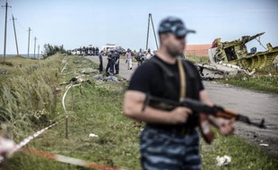 Un séparatiste pro-russe monte la garde devant les décombre de l'avion malaisien le 20 juillet 2014 près de Grabove dans la région de Donetsk