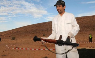 Un membre de la gendarmerie royal après la découverte de munitions appartenant à AQMI, le 5 janvier 2011 à Amgala près du Sahara