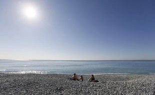 Des vacanciers profitent de la chaleur sur une plage de Nice le 7 mars 2014