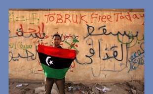 Un manifestant anti-Kadhafi brandit le drapeau de l'ancienne monarchie libyenne d'Idris Ier, le 24 février 2011 à Tobrouk.
