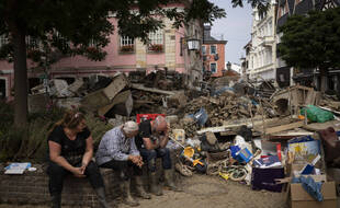 Des habitants de Bad Neuenahr-Ahrweiler, en Rhénanie-Palatinat, dans l'ouest de l'Allemagne, se reposent après avoir dégagé des décombres laissés par les inondations.