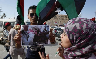 Un Libyen tient une photo de la dépouille de Kadhafi, le 20 octobre 2011.