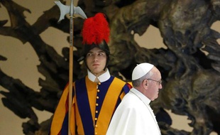 Le pape François passe devant un garde suisse, le 16 mars 2013, au Vatican.