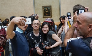 Des visiteurs du musée du Louvre font un selfie devant