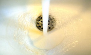 Photo réalisée le 19 novembre 2008 à Paris de l'eau d'un robinet coulant dans un évier. Paris va remunicipaliser le service de distribution d'eau potable de la ville, privatisé en 1984 par Jacques Chirac et aujourd'hui gérée par Veolia (rive droite) et Suez (rive gauche), conformément à une promesse de campagne du maire socialiste Bertrand Delanoë, a expliqué ce jour la première adjointe Anne Hidalgo, présentant la décision qui sera soumise lundi au Conseil de Paris.