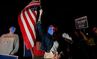 Une supportrice de Donald Trump porte un drapeau et manifeste devant un bureau de vote dans le Nevada, le 5 novembre 2020.