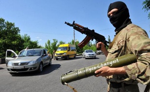 Un militant prorusse surveille les voitures le 20 mai 2014 à un point de passage près de la ville de Kramatorsk, dans l'est du pays