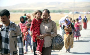 Un Irakien de la communauté yézidie traverse la frontière entre l'Irak et la Syrie à Fishkhabur le 11 août 2014