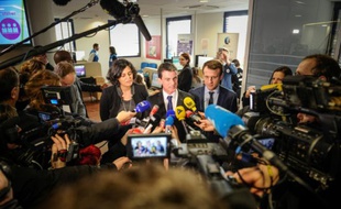 Manuel Valls (c), la ministre du Travail Myriam El Khomri et le ministre de l'Economie Emmanuel Macron, répondent aux journalistes, le 22 février 2016 à Mulhouse