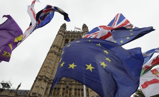 A confusion of various flags fly outside Parliament in London, Monday, Oct. 21, 2019. The European Commission says the fact that British Prime Minister Boris Johnson did not sign a letter requesting a three-month extension of the Brexit deadline has no impact on whether it is valid and that the European Union is considering the request.