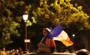 Une femme célèbre la victoire des Bleus sur les Champs-Elysées