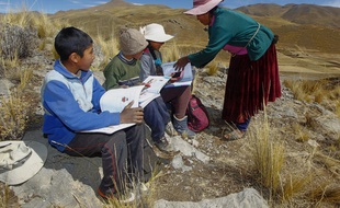 Raymunda Charca (à droite) aide ses enfants (G-D) Juan Carlos, 13 ans, Alvaro, 10 ans, and Roxana Cabrera, 16 ans, au sommet d'une colline où ils captent du réseau pour pouvoir suivre les cours à distance durant cette pandémie de coronavirus.