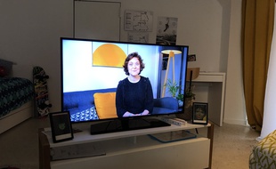 Sur un écran, Julie, une patiente, nous aide à comprendre comment fonctionne le jeu et nous donne quelques astuces.