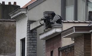 Un membre des forces spéciales prend position près de la maison perquisitionnée.