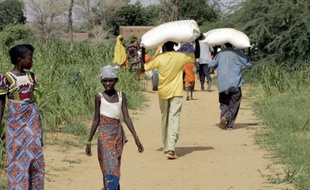 Des hommes portent des sacs de nourriture à Tolkobeye au Niger le 8 août 2005