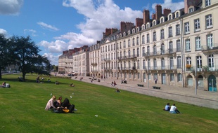 Des personnes profitent du soleil sur les pelouses du quai de Turenne à Nantes