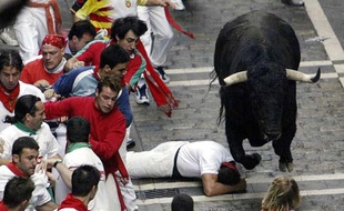 Un homme tombé près d'un taureau, lors d'un «encierro» de San Fermin, le 9 juillet 2003 à Pampelune.
