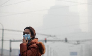 Une femme tente de se protéger de la pollution de l'air, à Pékin le 16 janvier 2014