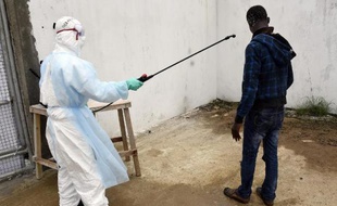 Un visiteur est décontaminé à son arrivée à l'hôpital Island à Monrovia (Libéria) où il est venu apporter de la nourriture à des proches souffrant du virus Ebola, le 26 septembre 2014