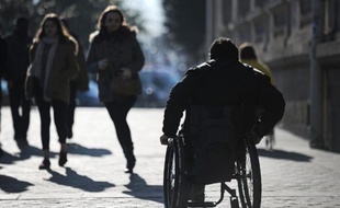 "Accessibilité en danger, l'Etat nous met à terre!" Une vingtaine de personnes handicapées ont quitté leurs fauteuils pour s'allonger sur le sol mercredi à l'orée de la place Beauvau, à Paris