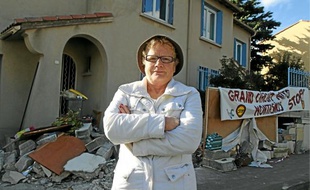 Marie-France Ragoso, du comité de quartier, devant un mur démoli.