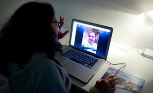 Une utilisatrice de Skype discute avec sa famille à l'étranger, via Skype, le 27 août 2013 à Stockholm, en Suède.