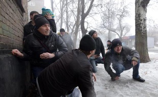 Des passants se mettent à l'abri pendant le bombardement d'un quartier de la ville de Donetsk, dans l'est séparatiste de l'Ukraine, le 30 janvier 2015