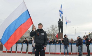 Un homme tient un drapeau nationaliste sur une place de Simferopol en Crimée, région autonome d'Ukraine.