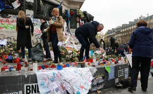 Des volontaires entretiennent les hommages place de la République le 30 novembre 2015 en mémoire des victimes des attentats du 13 novembre. La veille, des heurts ont éclaté entre forces de l'ordre et manifestants.