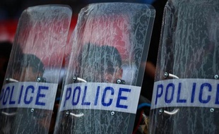 Des policiers égyptiens derrière leur bouclier de protection le 6 décembre 2014 au stade du Caire