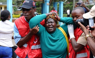 Des hommes de la Croix-Rouge kényane soutienne une femme qui vient d'apercevoir le corps d'un proche parmi les victimes de l'attentat de l'université de Garissa, dans un centre funéraire de Nairobi, le 3 avril 2015.